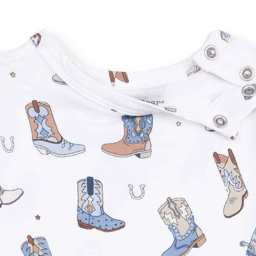an all-over print of cowboy boots in shades of blue, brown, and beige and snaps at the shoulder