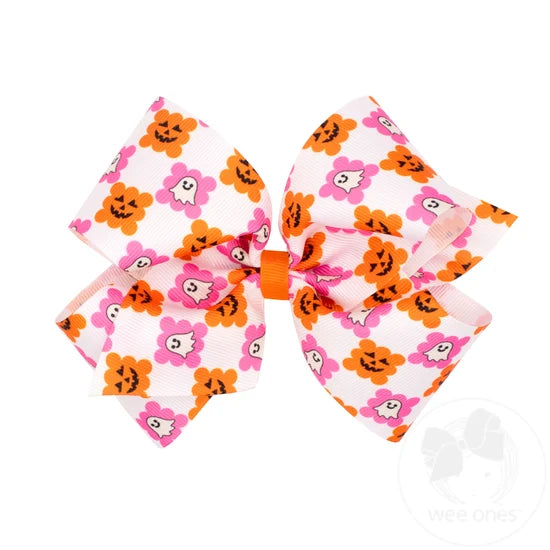 White bow with a checkered pattern featuring ghosts and jack o lanterns.