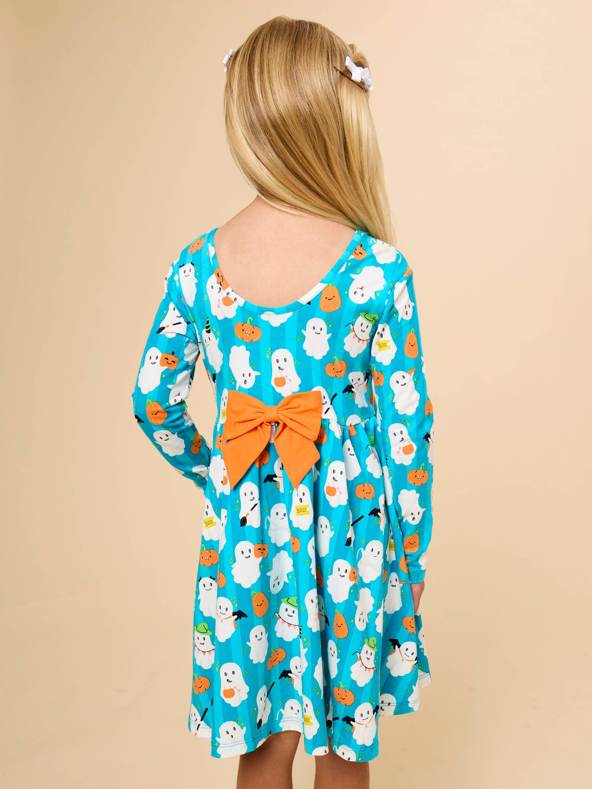 CLose up of back of aqua ghost dress with orange bow on the back. 