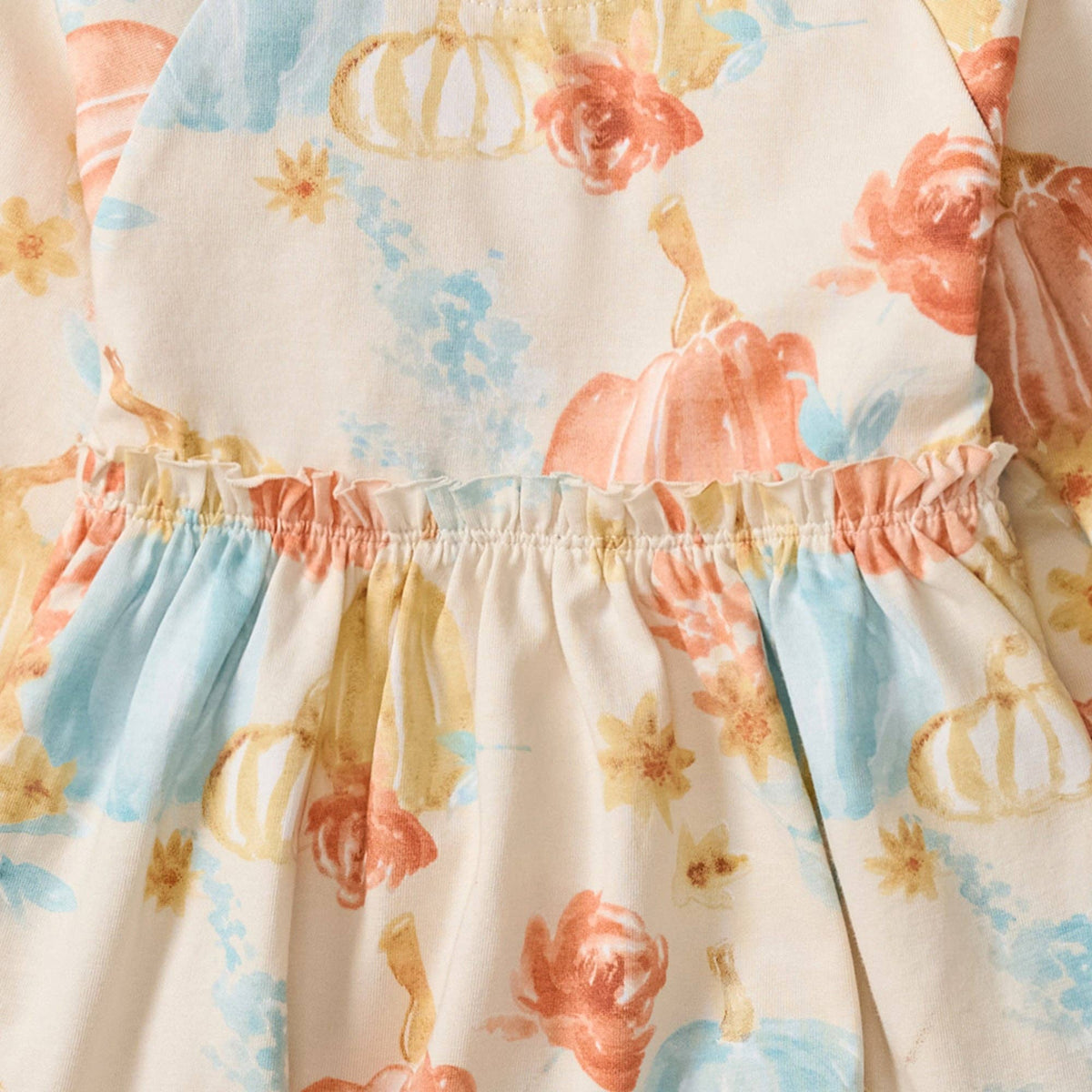 Floral patterned fabric with pumpkins and flowers on a white background