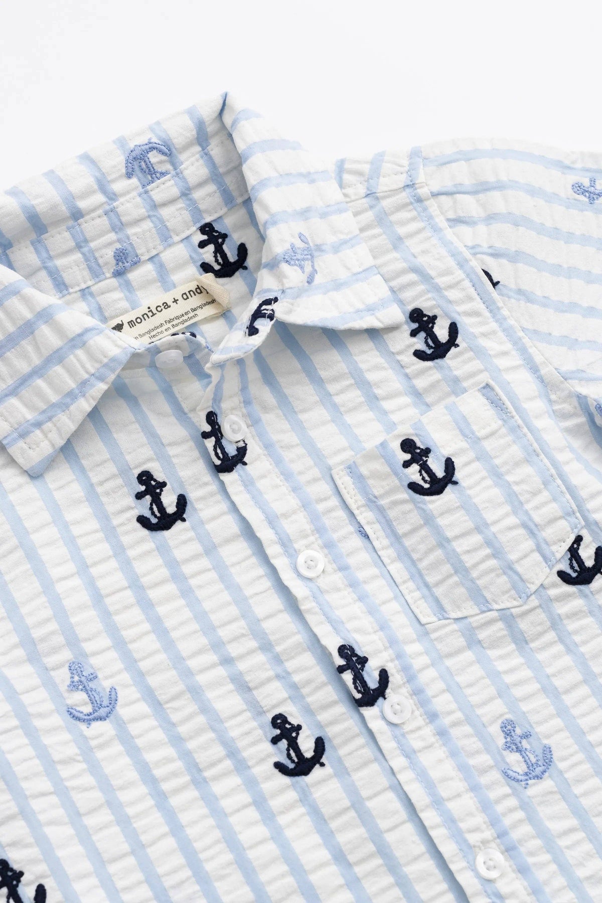 Children's shirt with blue and white stripes and embroidered anchors on a white background