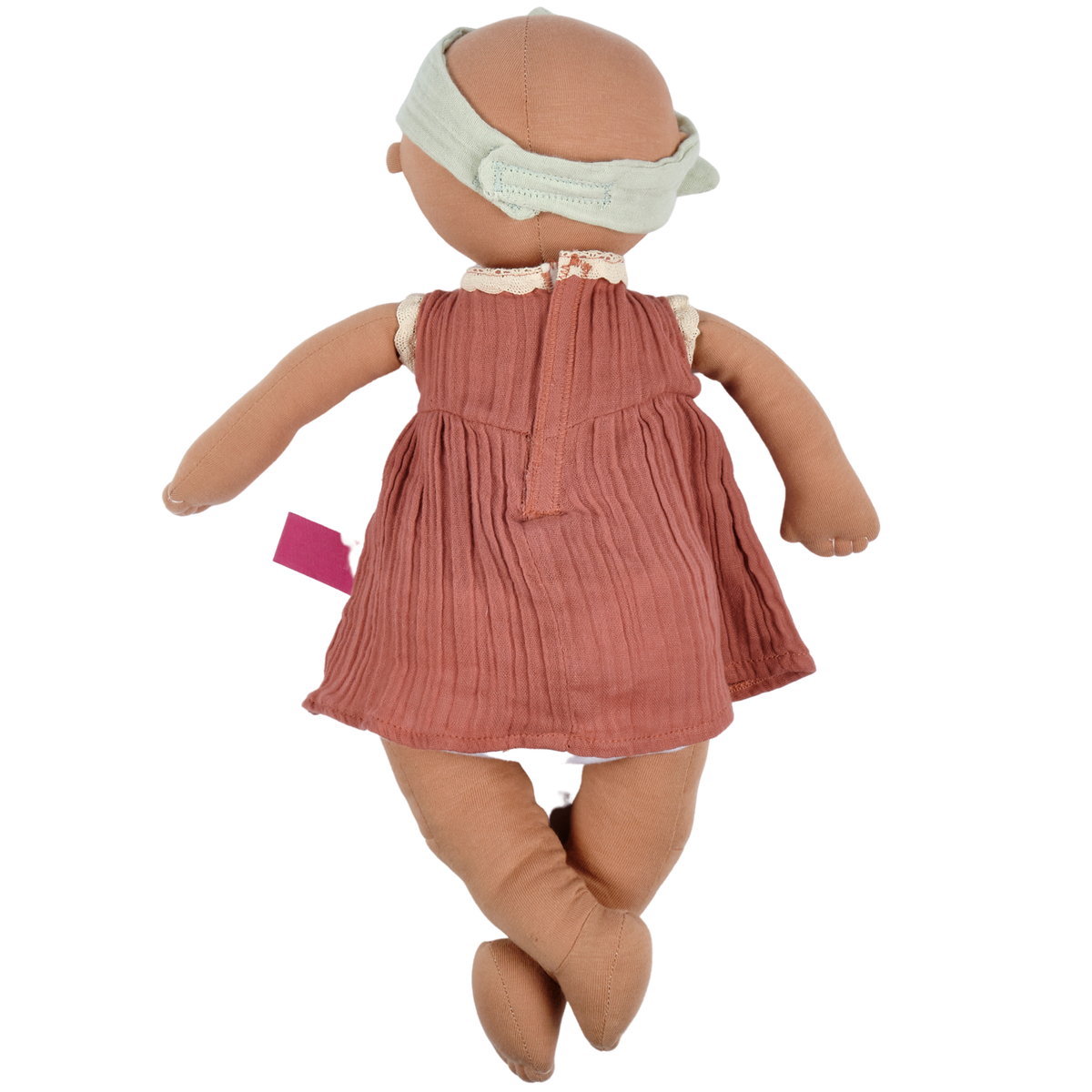 Back view of a baby doll wearing a dusky pink dress against a white background. 