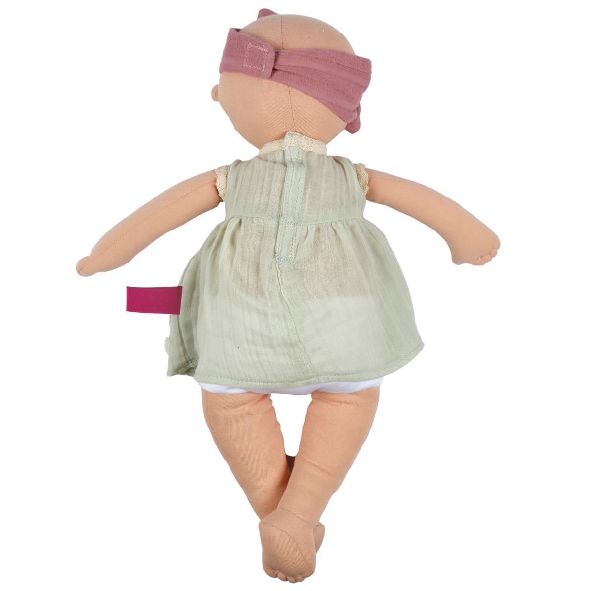 Plush baby doll in a light dress and a dusty pink headband, rear view. 