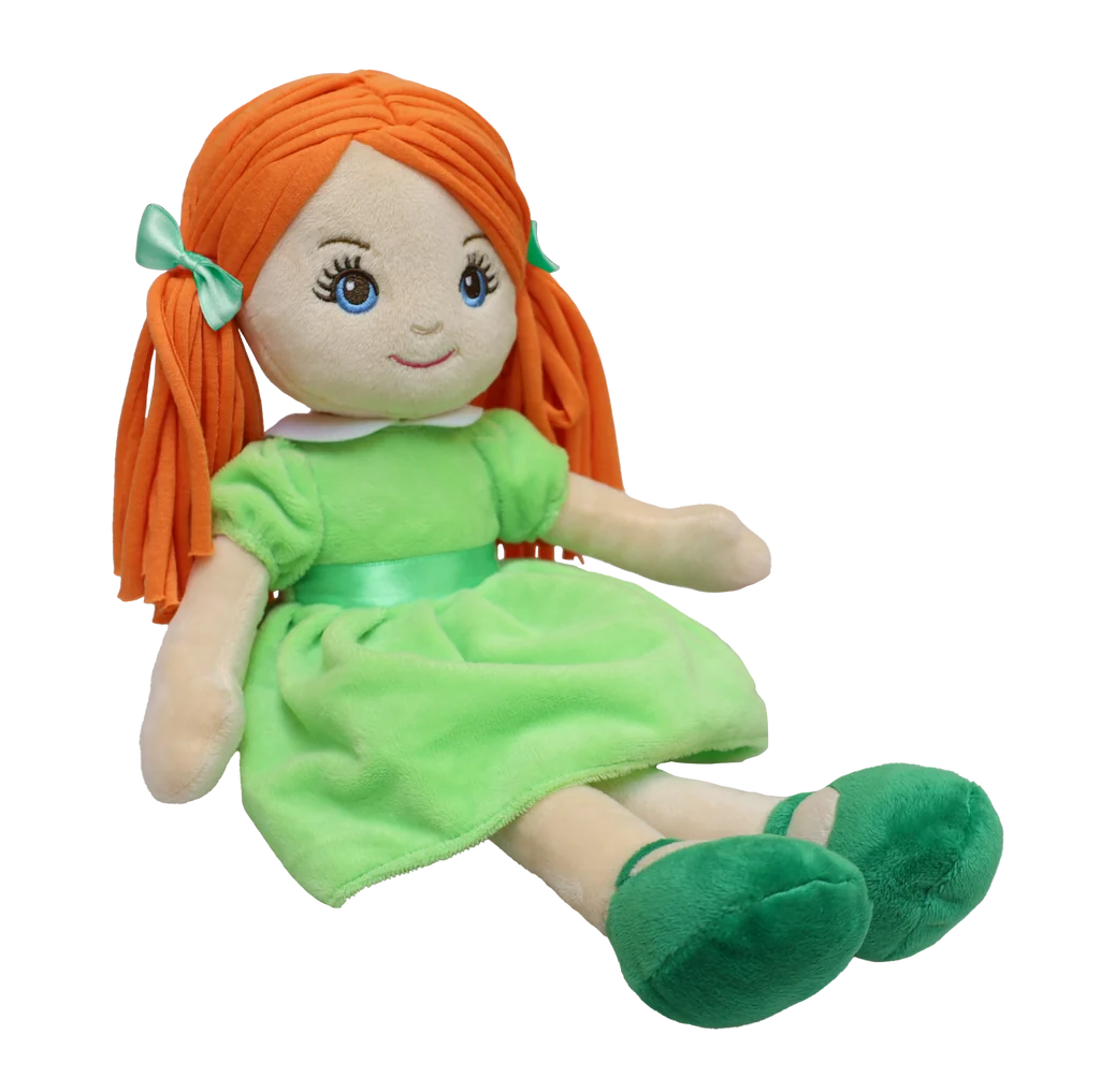A pale doll with red pigtails and green eyes wearing  a green dress, green shoes, and has green bows to match sits against a white background. 