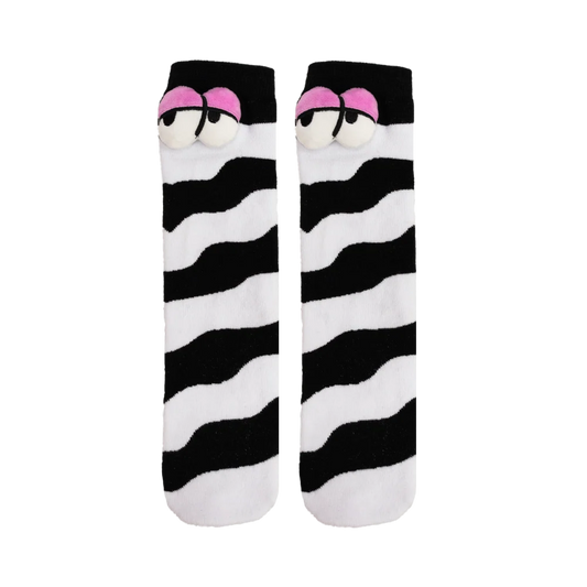 Pair of black and white socks with plush eyes on each, against a white background. 