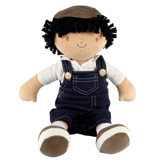 Plush toy with black hair, white shirt, navy overalls, and brown shoes on a white background