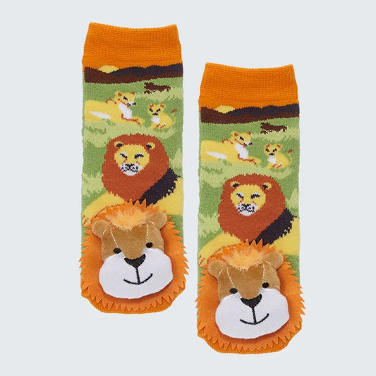 Socks with lions adorning them on a grassland with the sun setting in the background with lion plush head at the toes, against a white background. 