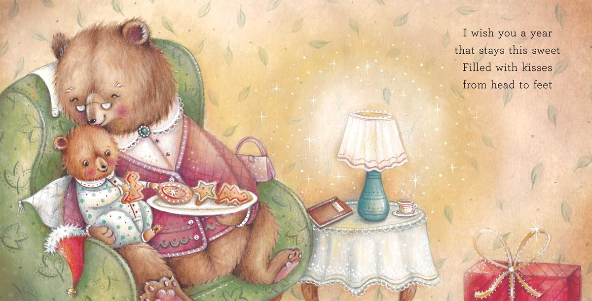 A vintage-style illustrated card or print showing a large brown bear in a pink robe hugging a smaller teddy bear while holding a tray of cookies. A small table with a lamp sits beside them, and the right side contains a poem reading, 'I wish you a year that stays this sweet / Filled with kisses from head to feet.