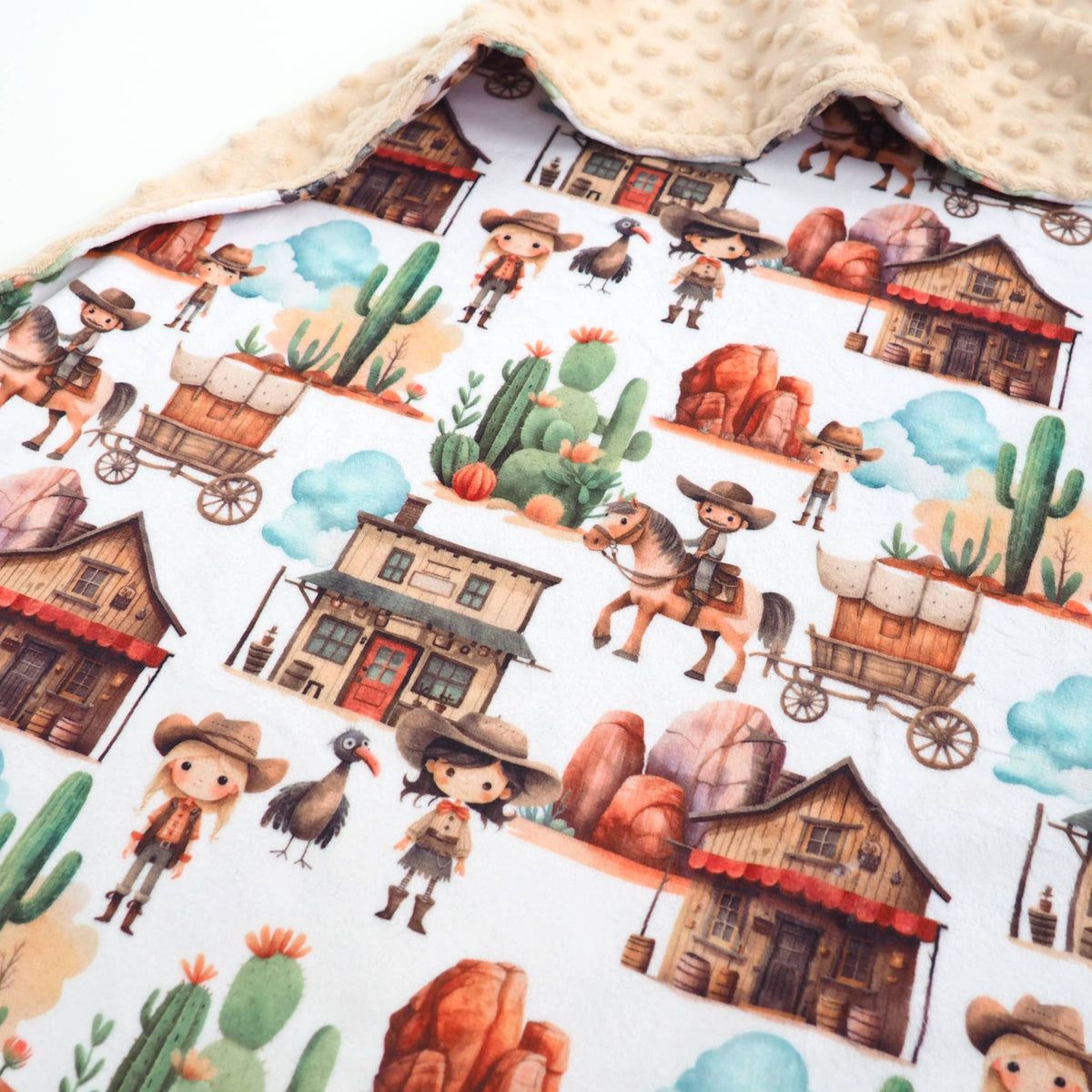 Western themed pattern on a white blanket with a tan backside