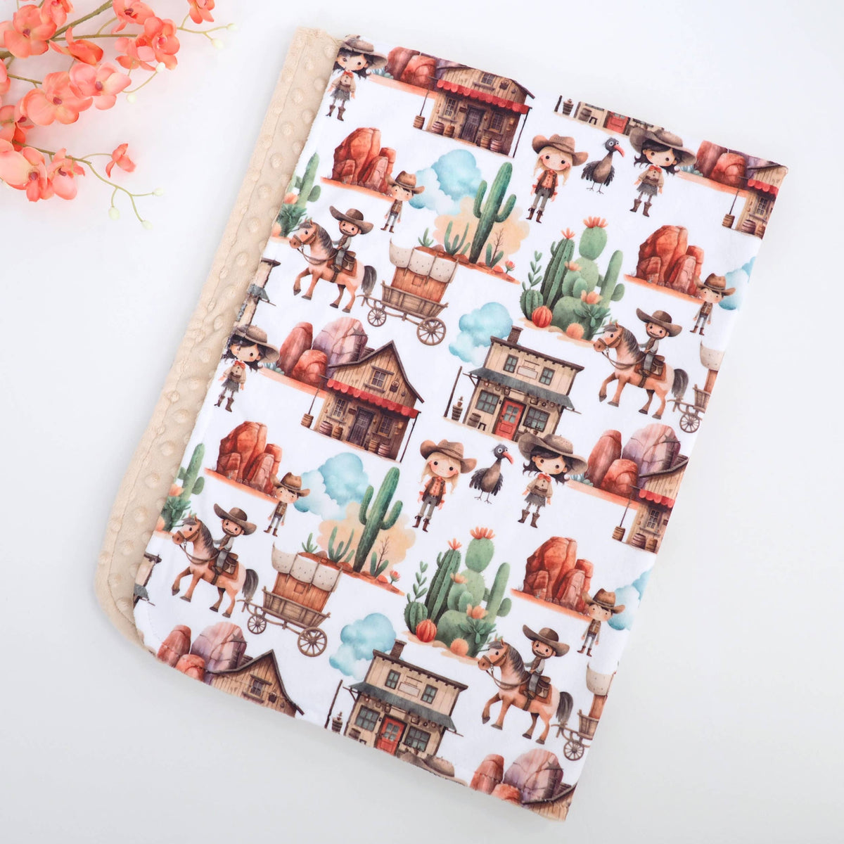 Western themed pattern on a white blanket with a tan backside