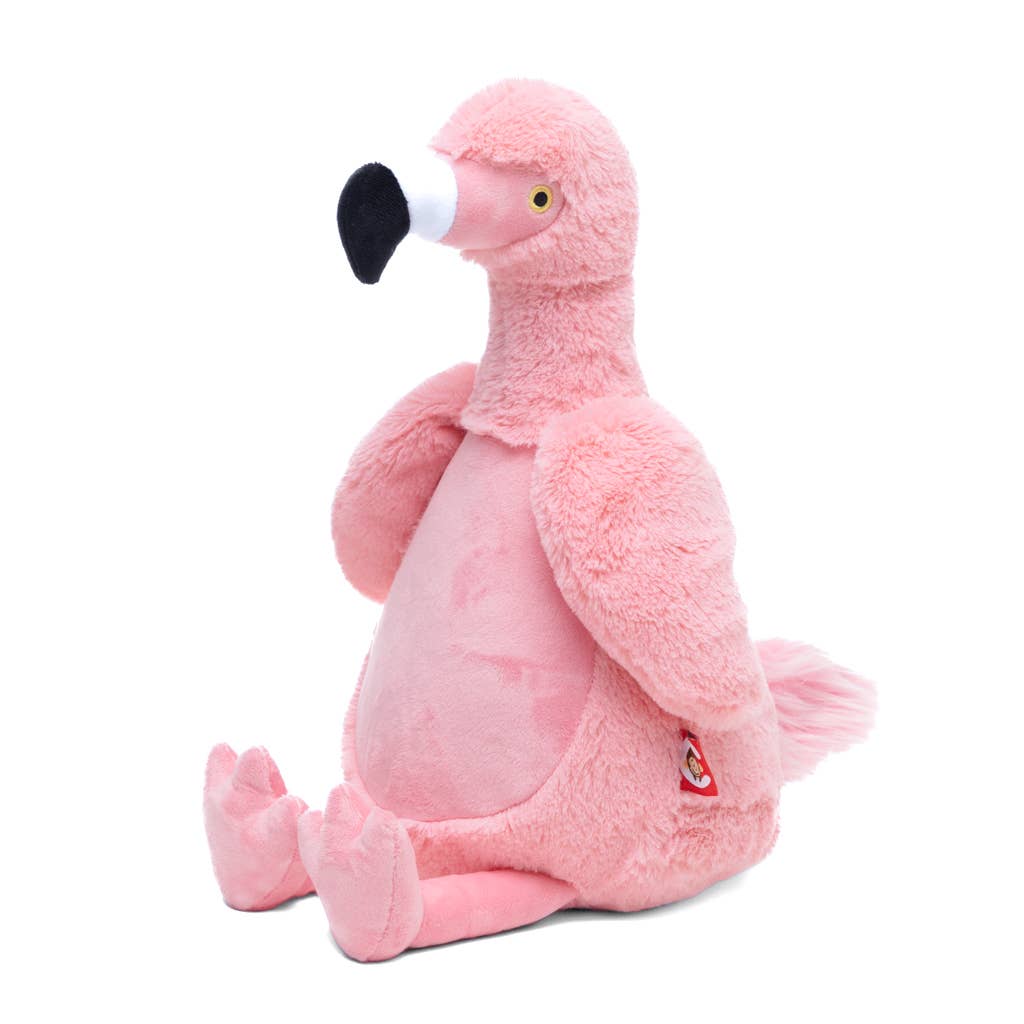 Pink stuffed flamingo seated on a white background