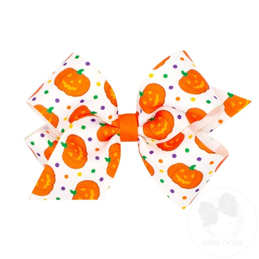 White bow with jack o lanterns and various colorful polka dots. 