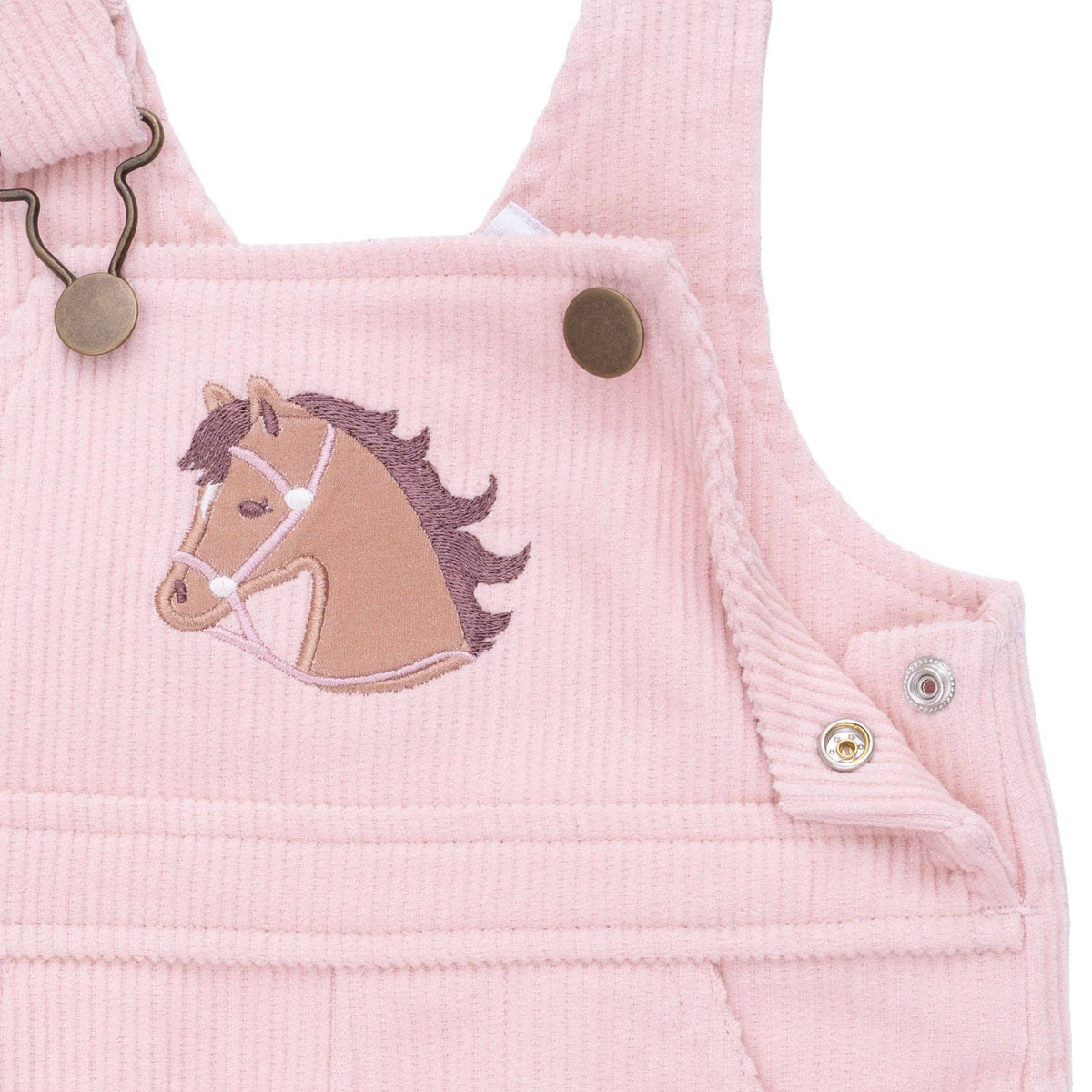 close up on applique horse on pink overall