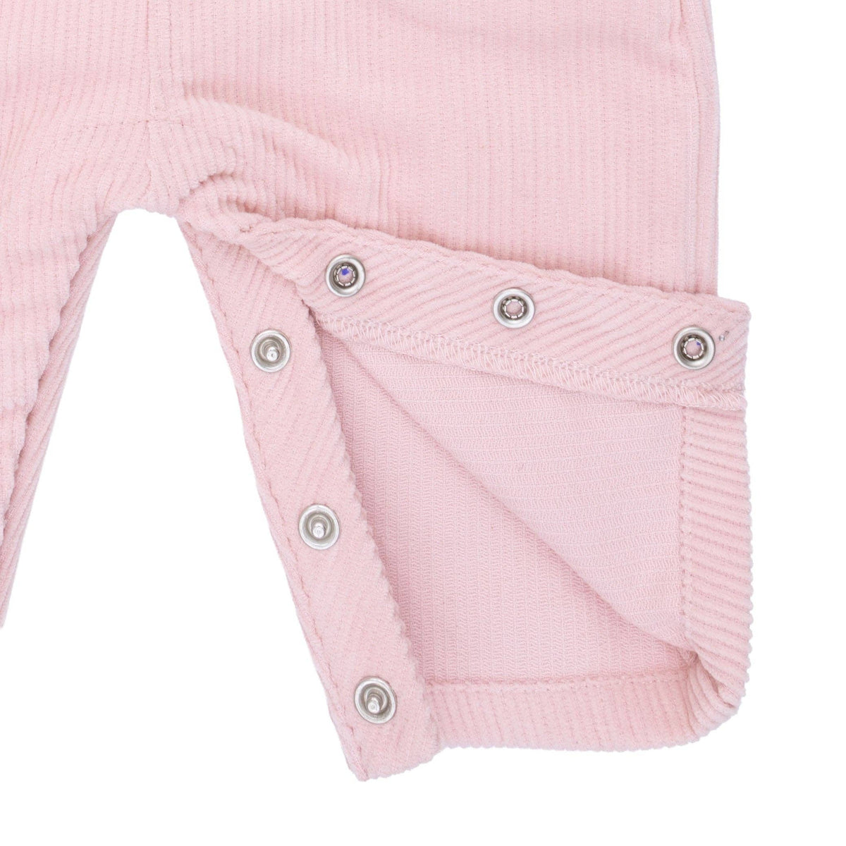close up of snaps on a corduroy overall on a white background
